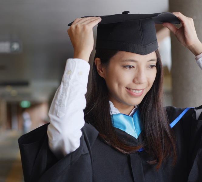 Image of person trying on graduation cap 